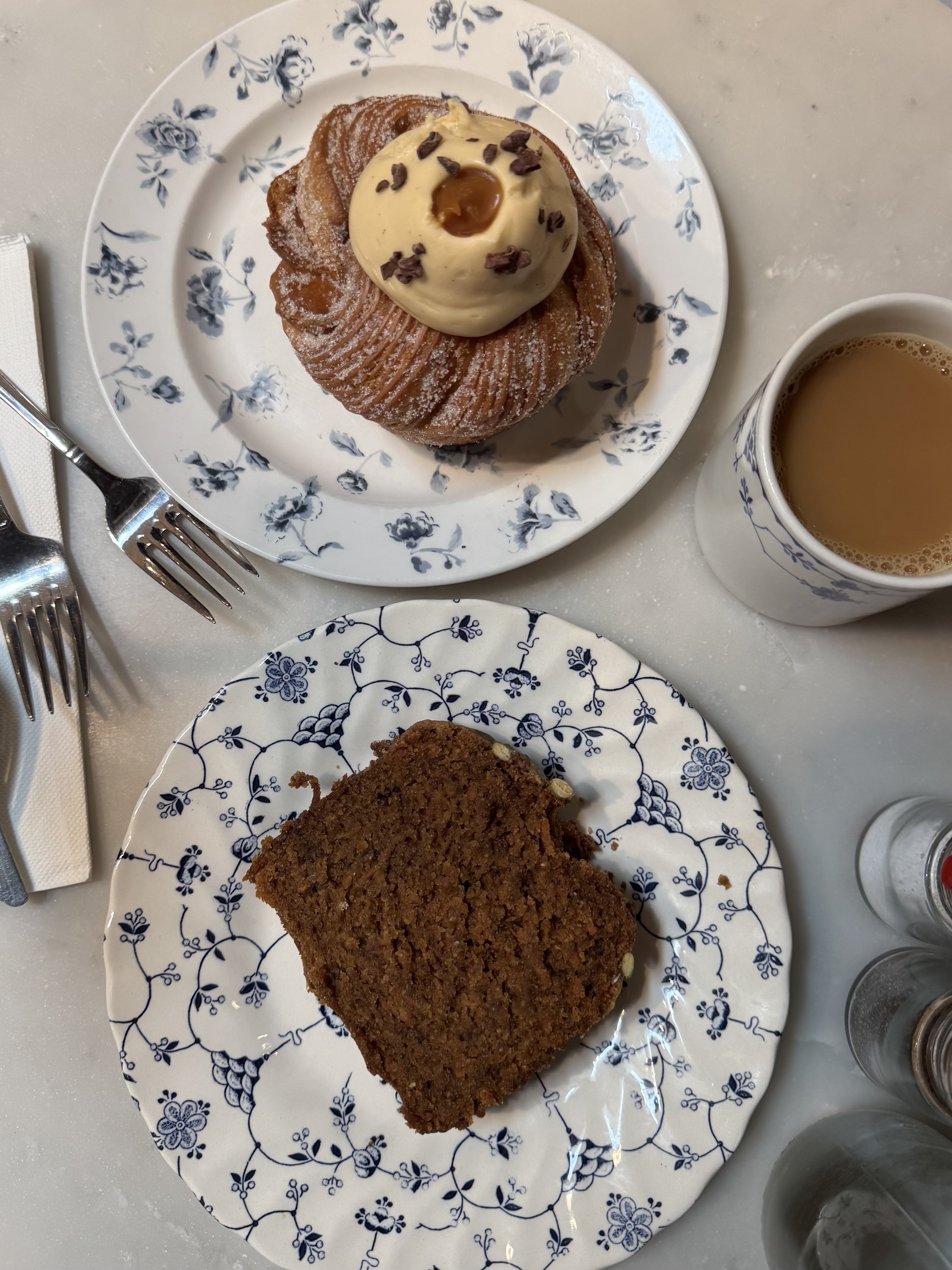 A bakery pastry with caramel and cocoa nibs, plated on blue floral china