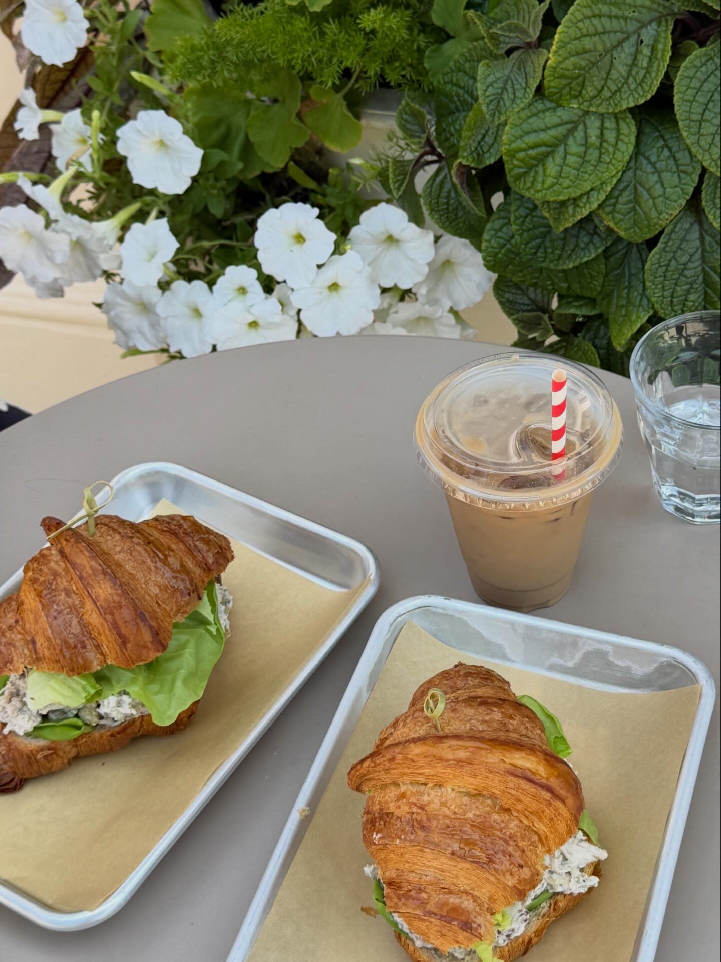 Croissant sandwiches and iced coffee on a café table