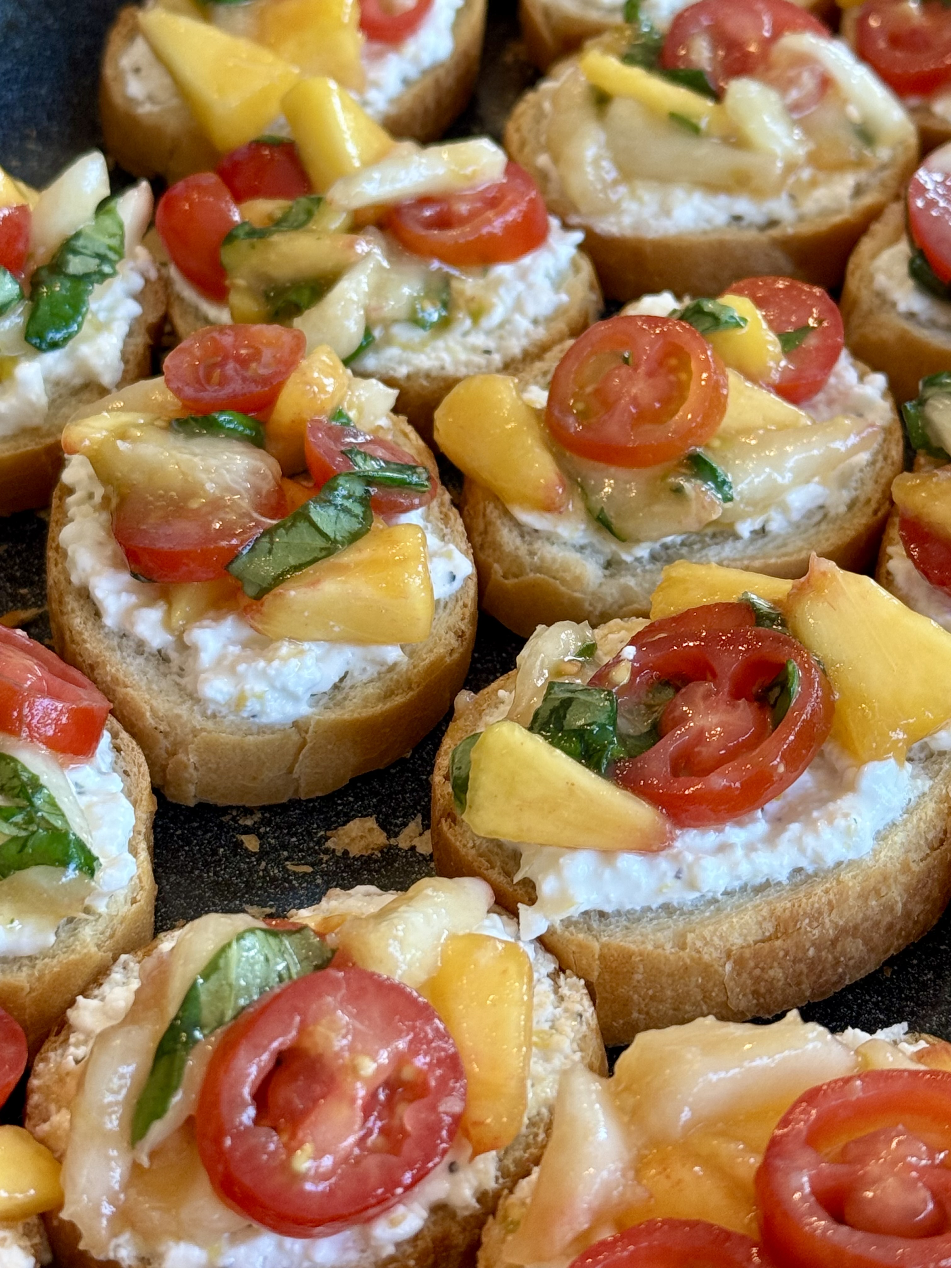 Crostini bites with peach, tomato, and burrata