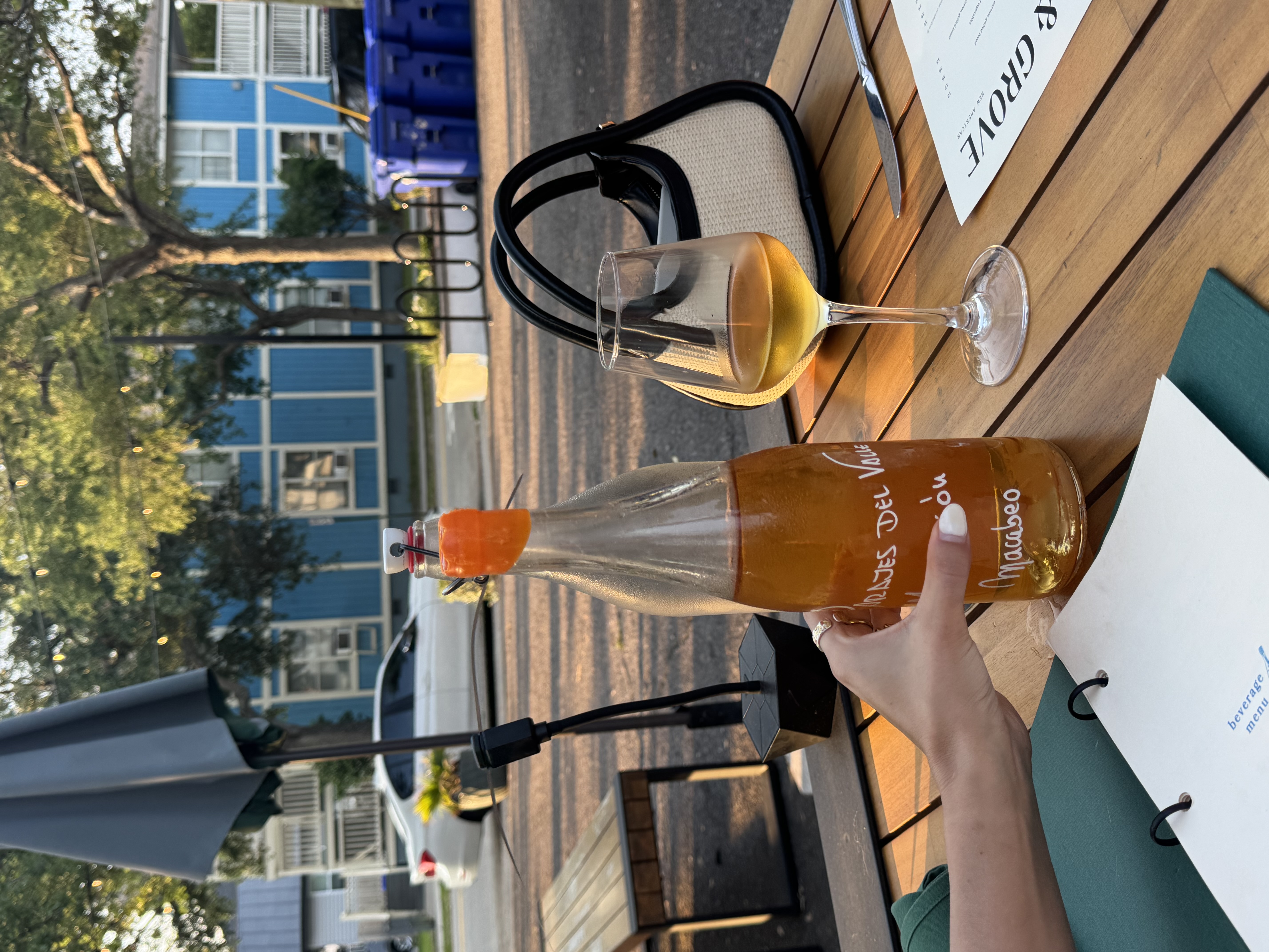 A bottle of natural wine on a patio at golden hour